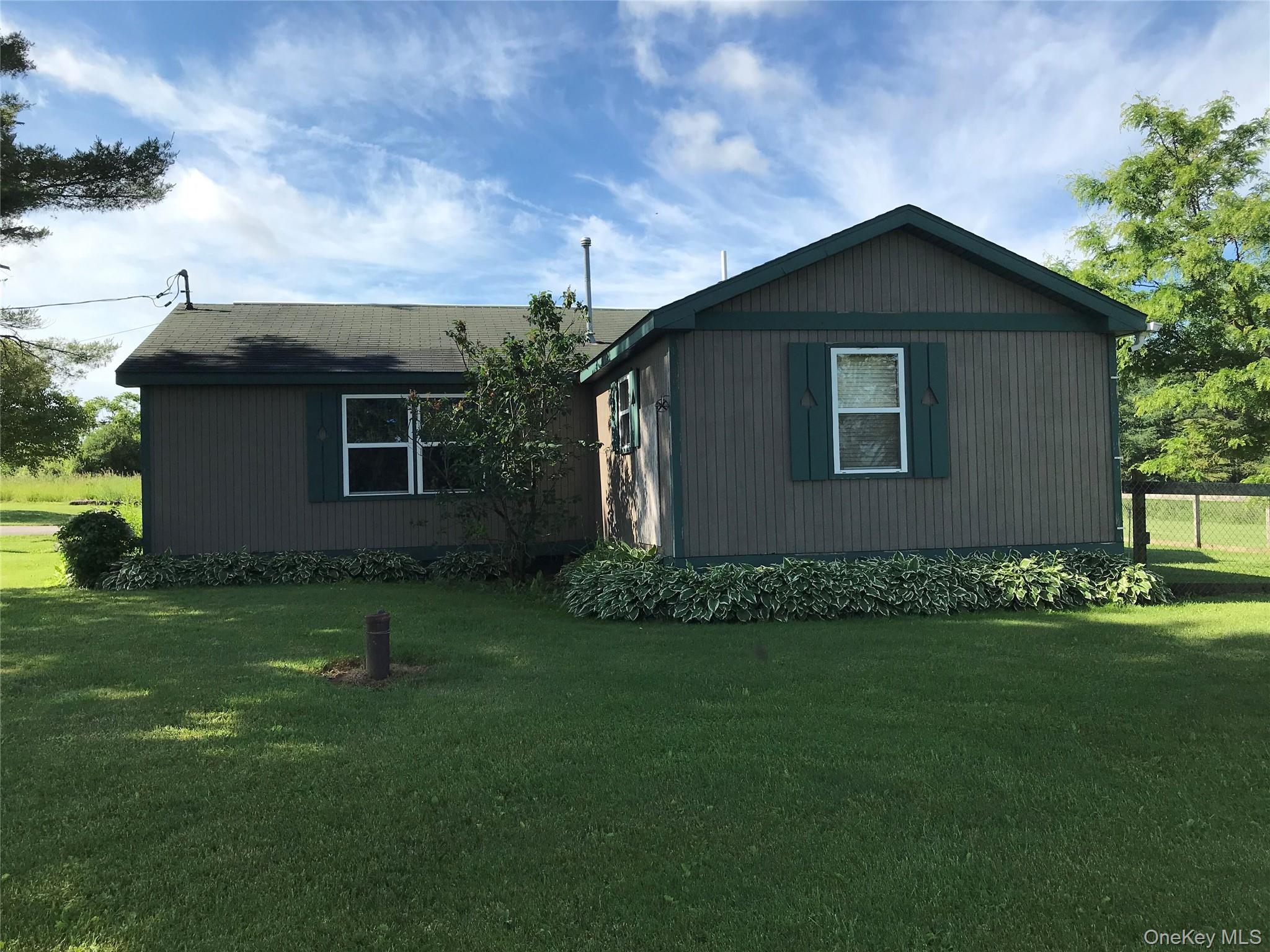471 Youngs Road Jordanville, NY 13361 - Photo 2 of 12 a front view of a house with a garden