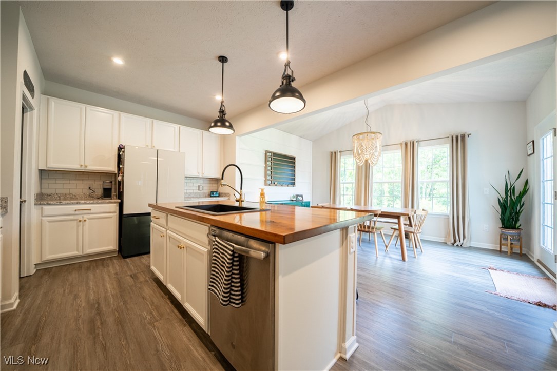 270 Stone Ridge Way Berea, OH 44017 - Photo 12 of 30 Kitchen with a center island with sink, sink, vaulted ceiling, stainless steel dishwasher, and white cabinets