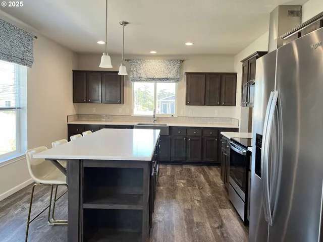 a kitchen with a refrigerator a sink and cabinets