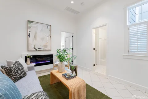 a living room with furniture fireplace and a potted plant