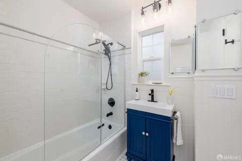 a bathroom with a bathtub shower sink vanity and a toilet