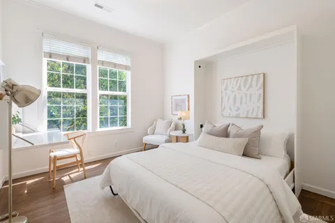 a bedroom with a bed and a large window
