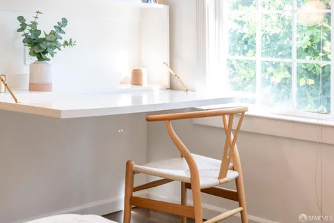 a view of a dining room with furniture and a potted plant