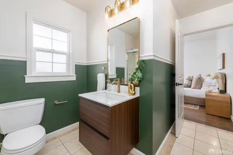 a bathroom with a toilet sink and mirror