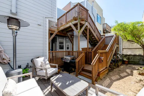 a view of a house with backyard and sitting area