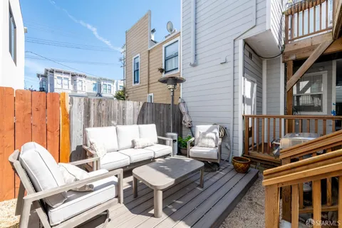 a view of a patio with couches table and chairs and wooden floor