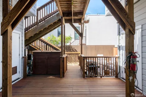 a view of balcony with wooden floor and seating