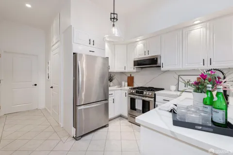 a kitchen with stainless steel appliances granite countertop a refrigerator a stove a sink and a refrigerator