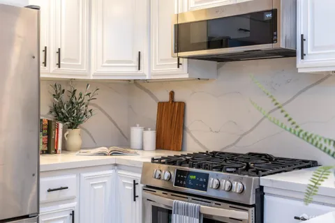 a stove top oven sitting inside of a kitchen