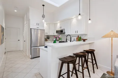 a kitchen with stainless steel appliances a refrigerator a sink cabinets and a counter top space