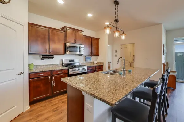 a kitchen with kitchen island a sink dining table and chairs