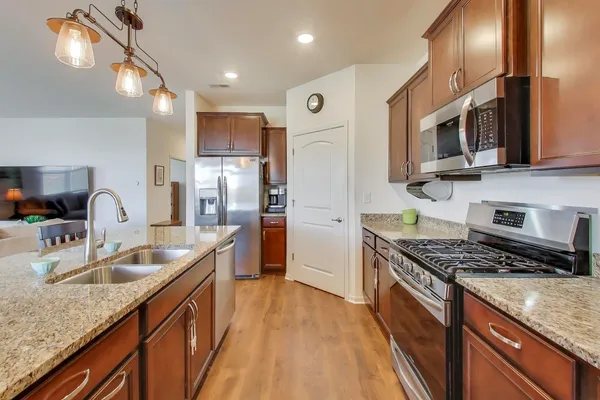 a kitchen with stainless steel appliances granite countertop a sink stove and refrigerator