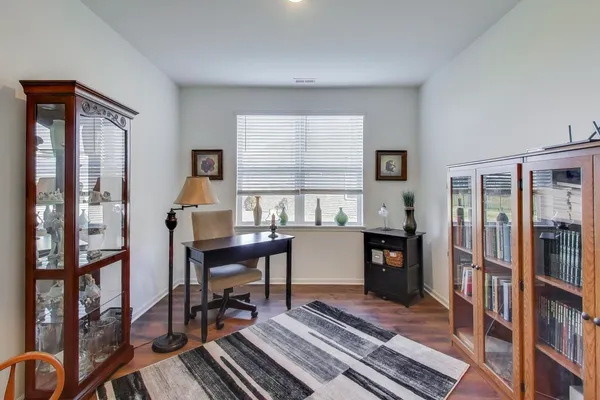 a view of a workspace with furniture and a window