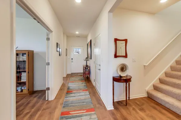 a view of a hallway with wooden floor and stairs