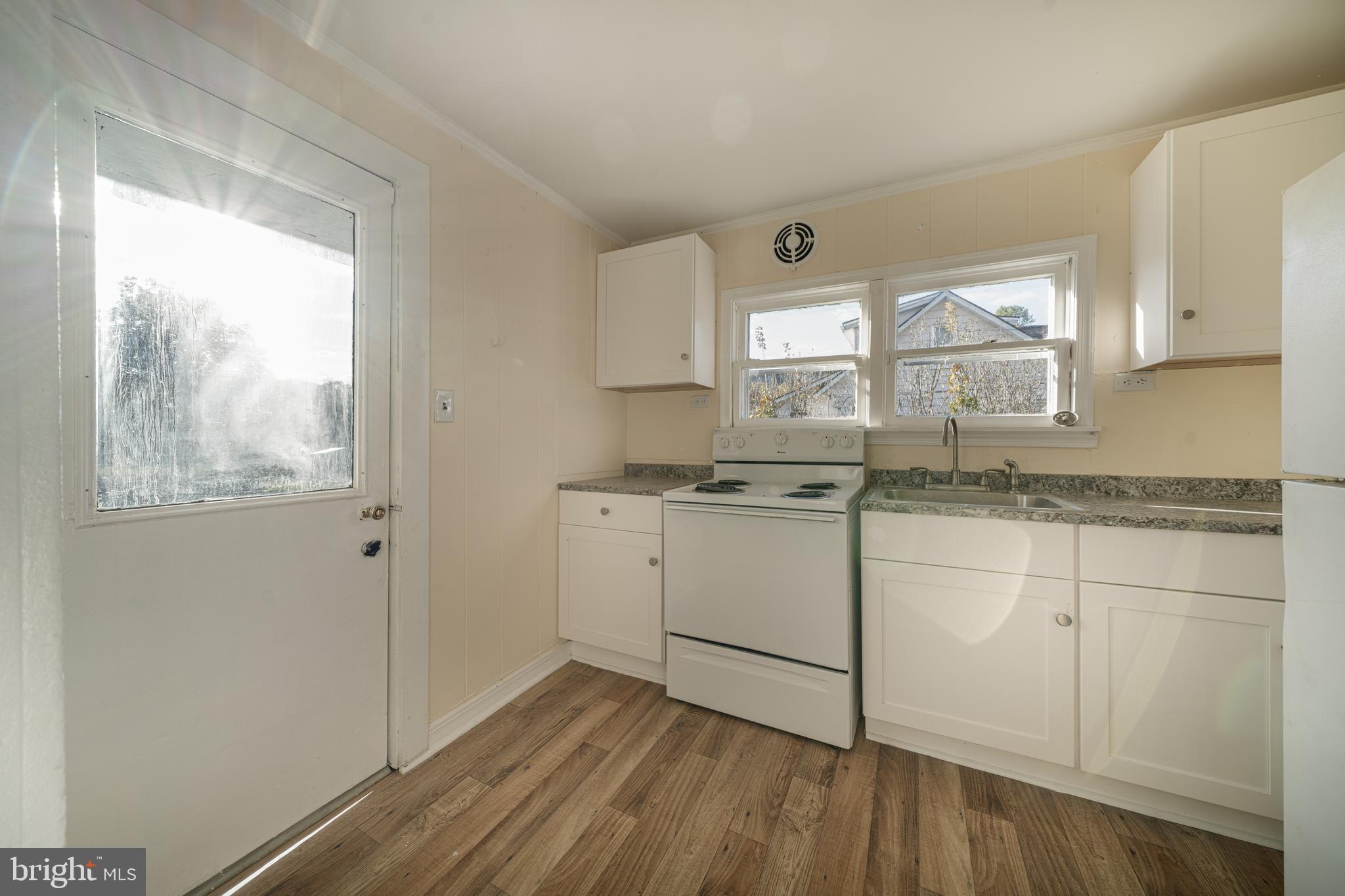 25329 Highfield Road Cascade, MD 21719 - Photo 28 of 51 a kitchen with granite countertop white cabinets and white appliances with wooden floor