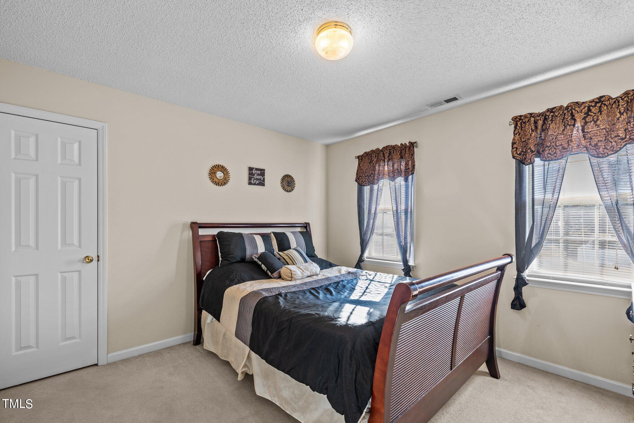 1516 Harvey Johnson Road Raleigh, NC 27603 - Photo 23 of 41 a bed sitting in a bedroom next to a window