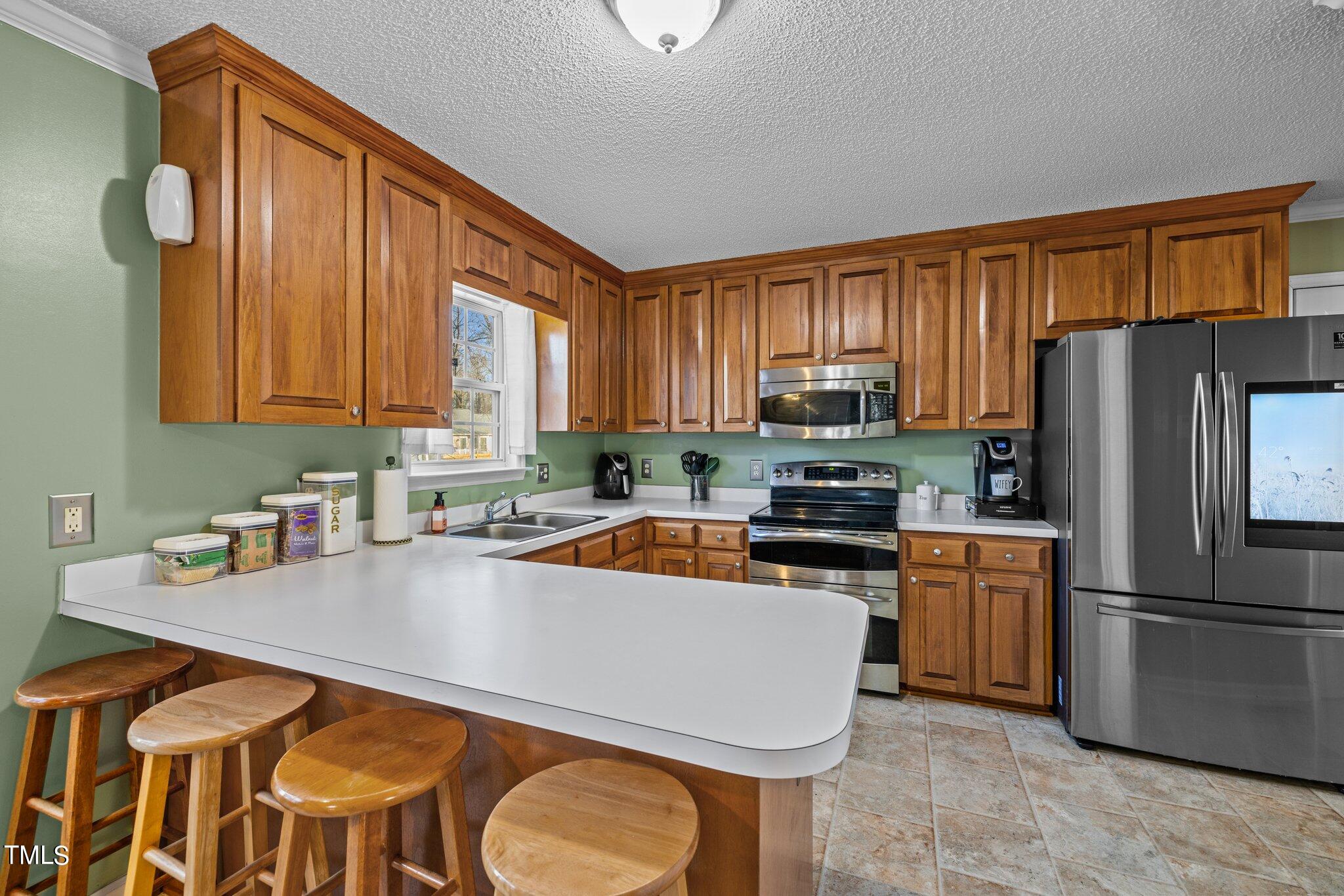 1516 Harvey Johnson Road Raleigh, NC 27603 - Photo 9 of 41 a kitchen with stainless steel appliances granite countertop a refrigerator a stove top oven a sink and dishwasher