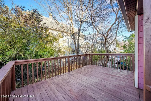 a balcony with wooden floor and wooden fence