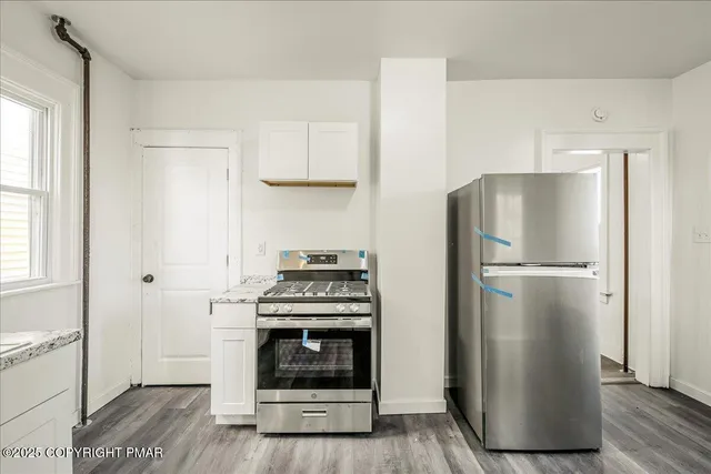 a kitchen with a refrigerator and a stove top oven