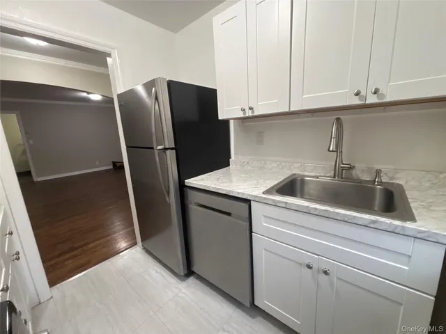 a kitchen with a refrigerator sink and cabinets