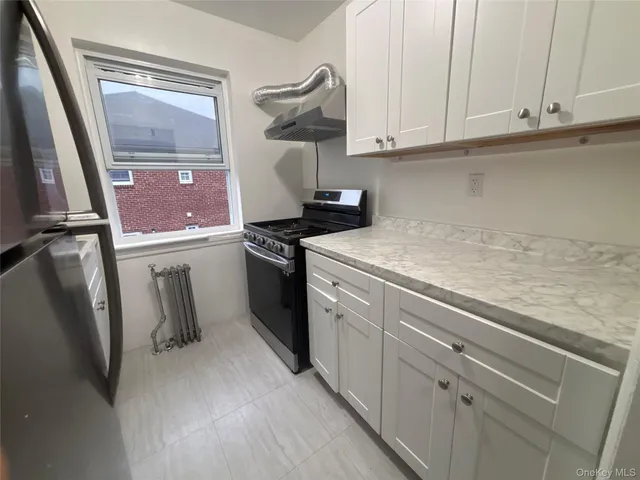 a kitchen with stainless steel appliances white cabinets and a stove