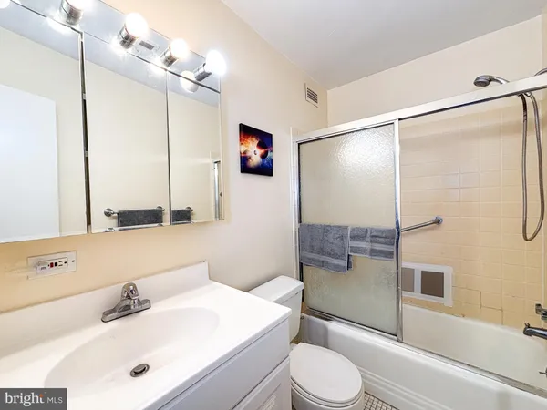 a bathroom with a sink vanity granite toilet and shower