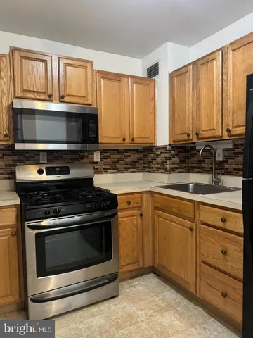 a kitchen with granite countertop cabinets stainless steel appliances and a window