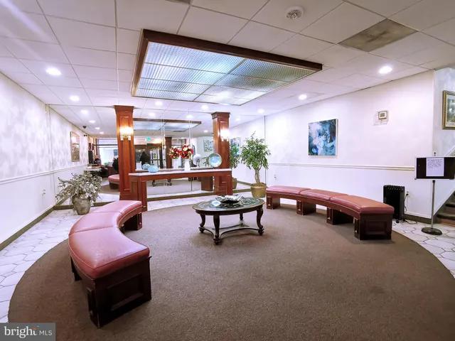 a living room with furniture a air conditioner and a potted plant