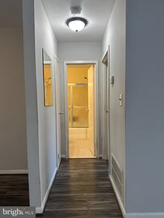 a view of a hallway with wooden floor