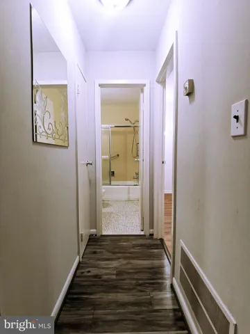 a view of a hallway with wooden floor and staircase