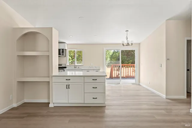 a kitchen with stainless steel appliances granite countertop a stove a sink and a refrigerator with wooden floors