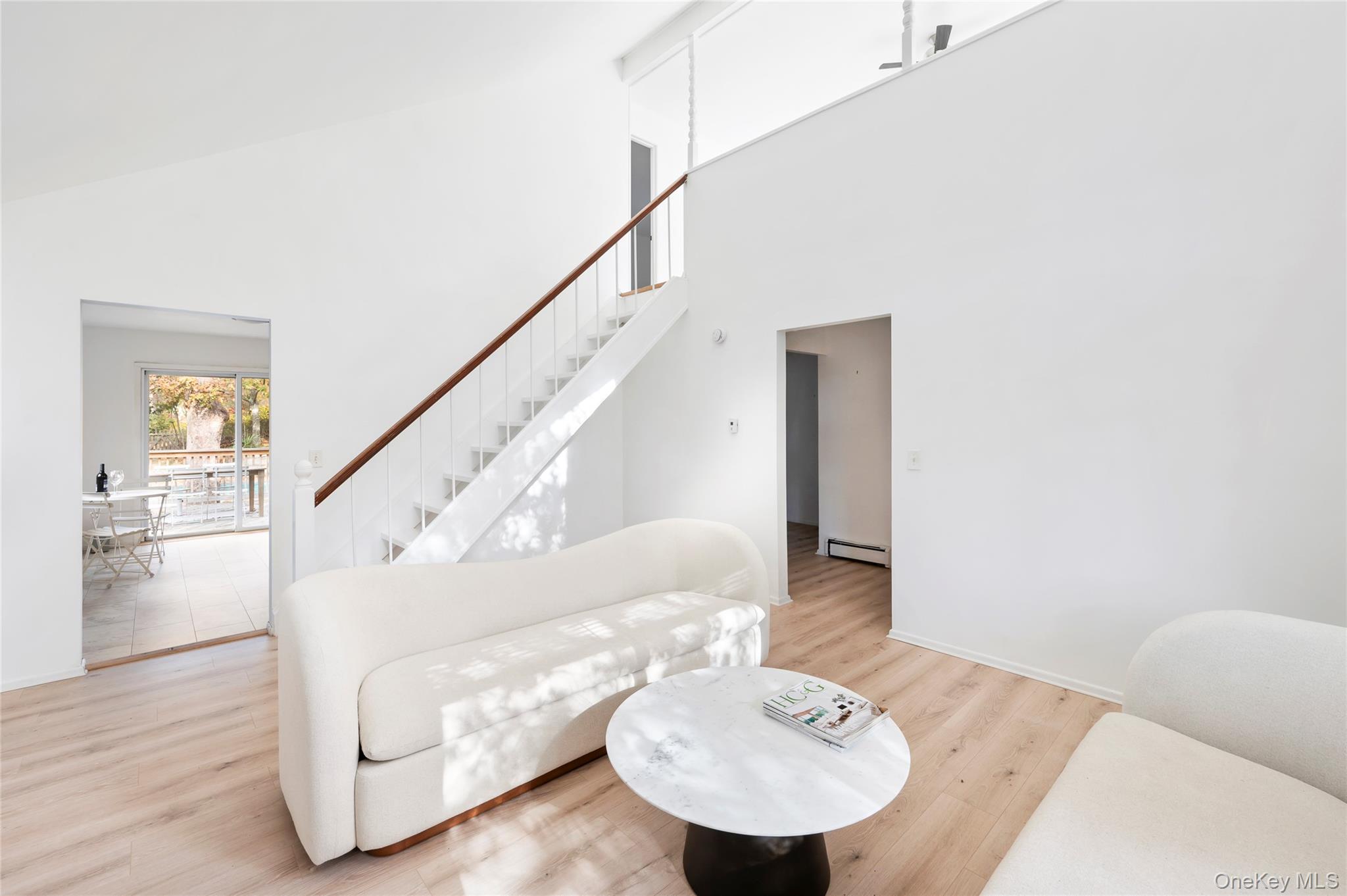 16 Peconic Road Hampton Bays, NY 11946 - Photo 2 of 13 a living room with furniture and a dining table