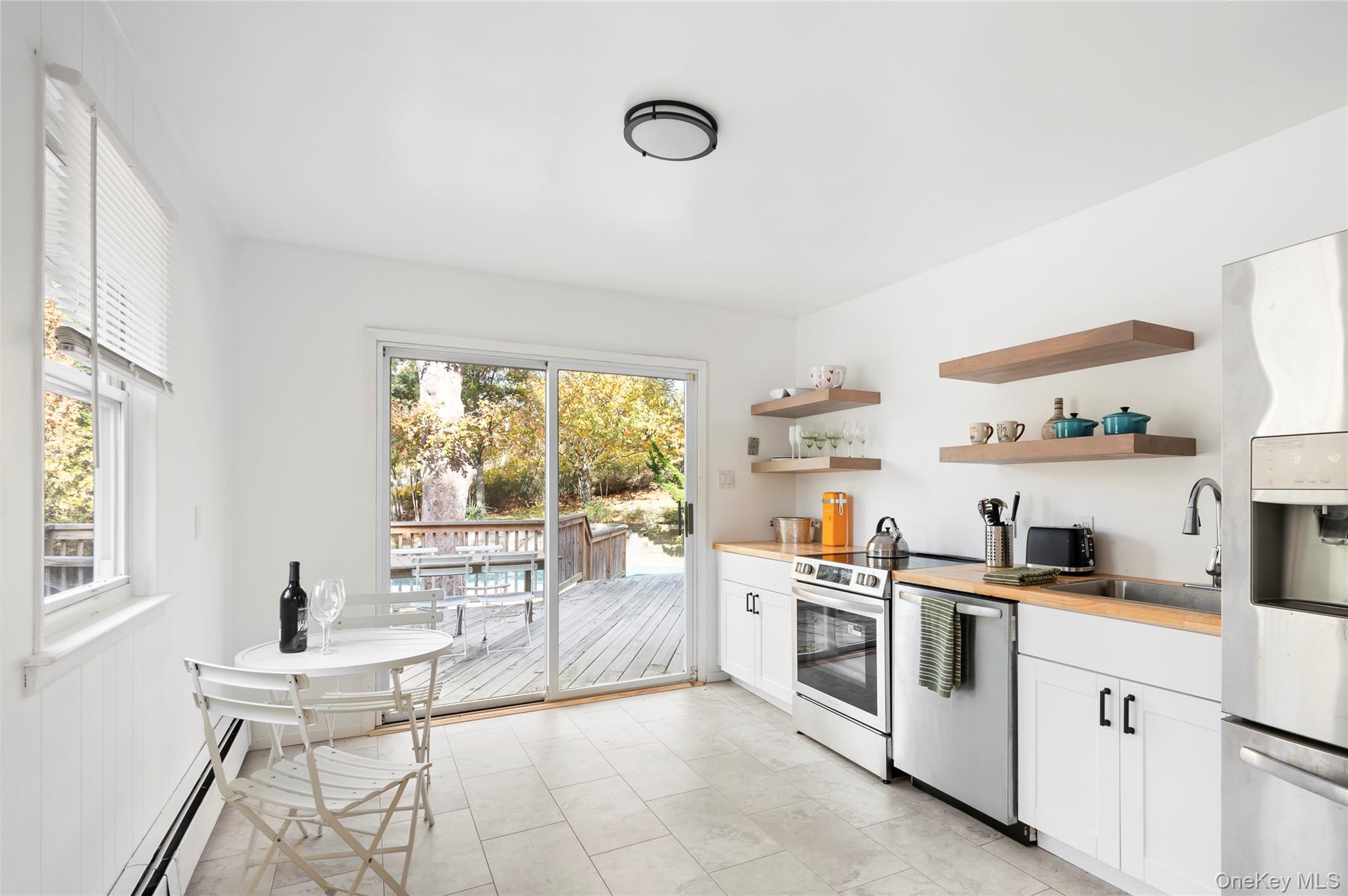 16 Peconic Road Hampton Bays, NY 11946 - Photo 4 of 13 a kitchen with white cabinets and white appliances