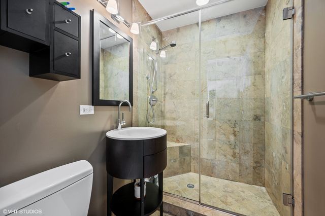 a bathroom with a sink a toilet and shower