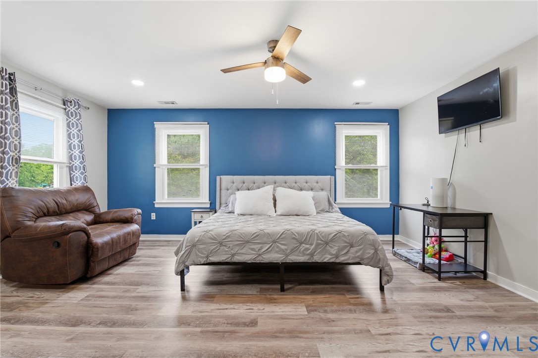 9110 Gayton Road Henrico, VA 23229 - Photo 21 of 54 a spacious bedroom with a bed a couch and a flat screen tv