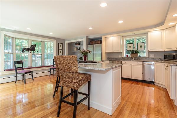 18 Dorset Road Belmont, MA 02478 - Photo 5 of 23 a kitchen with a table chairs refrigerator and cabinets