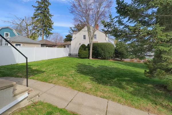 a view of a house with a yard and a street