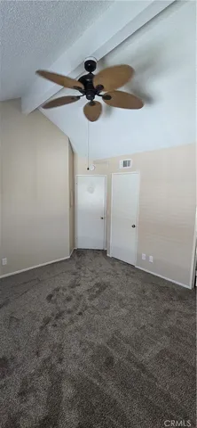 a view of a room with a ceiling fan and window