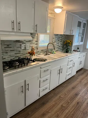 a kitchen with stainless steel appliances granite countertop a sink a stove and cabinets
