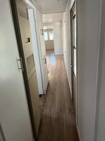 a view of a hallway with wooden floor and staircase