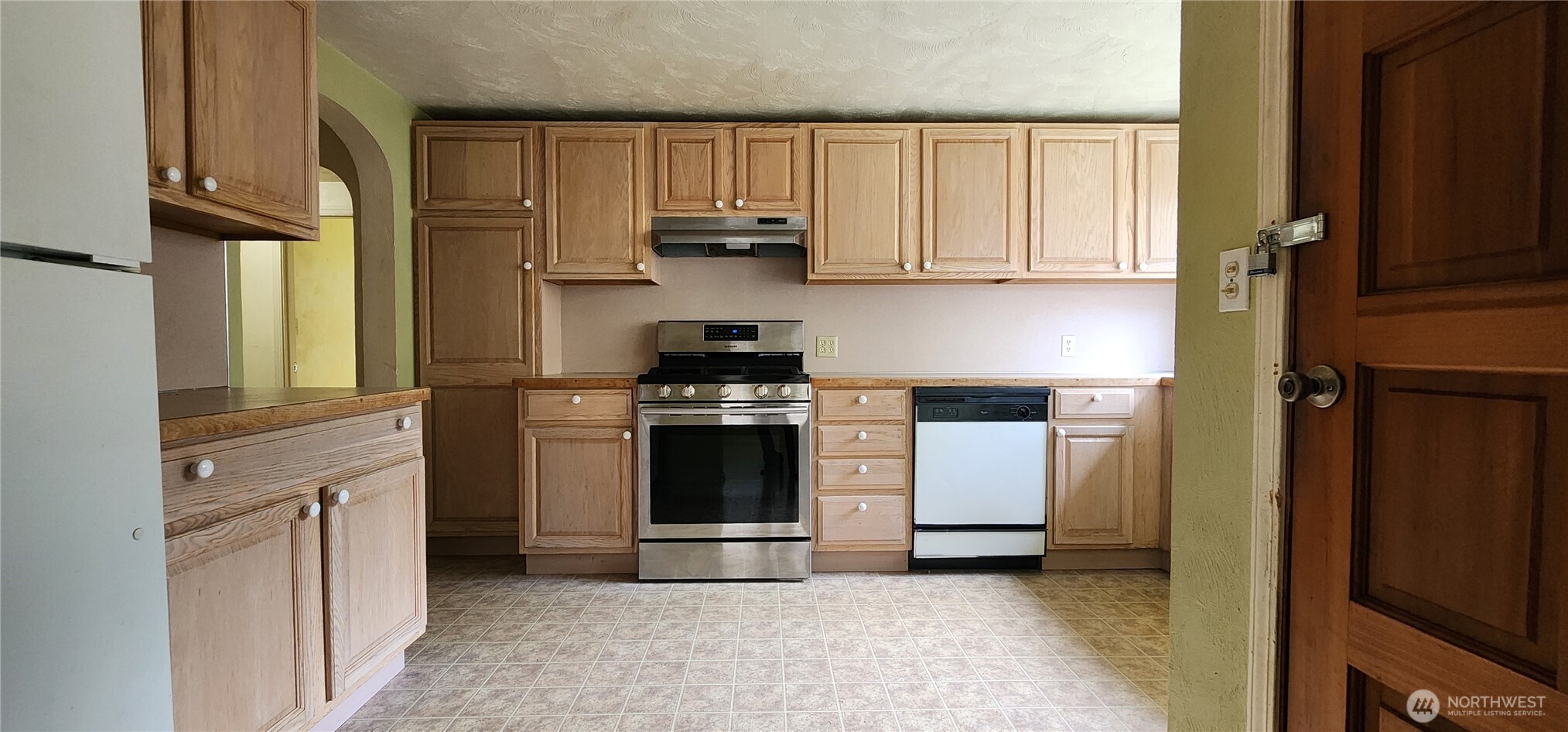 3225 Cooper Point Road Northwest Olympia, WA 98502 - Photo 24 of 40 a kitchen with stainless steel appliances granite countertop a stove a sink and a refrigerator