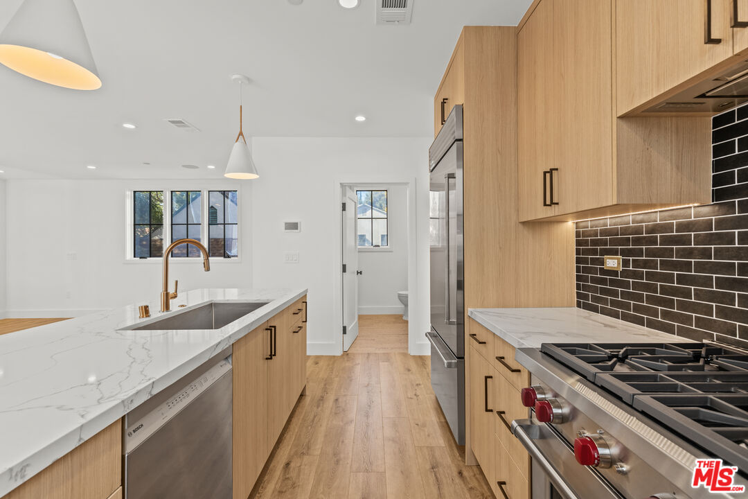 a kitchen with kitchen island granite countertop a sink stove and refrigerator