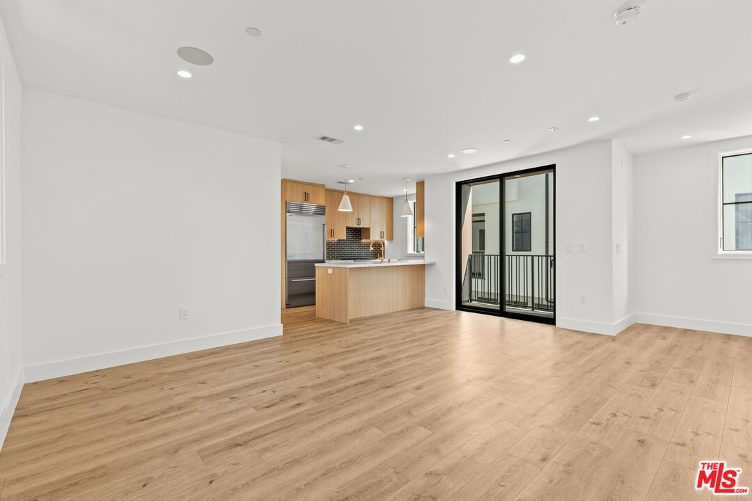 5538 Tova Road Sherman Oaks, CA 91411 - Photo 3 of 19 a view of an empty room with wooden floor and a kitchen