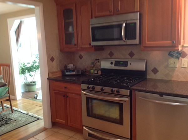 24 Tanglewood Road Needham, MA 02494 - Photo 5 of 8 a kitchen with granite countertop a stove top oven microwave and cabinets