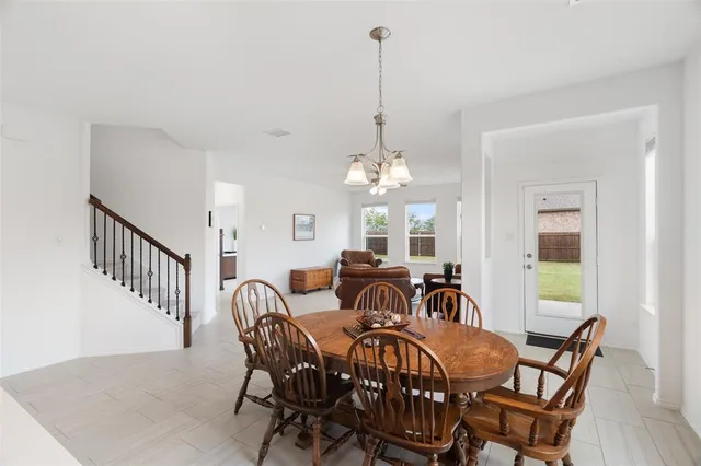 a view of a dining room with furniture a chandelier and wooden floor
