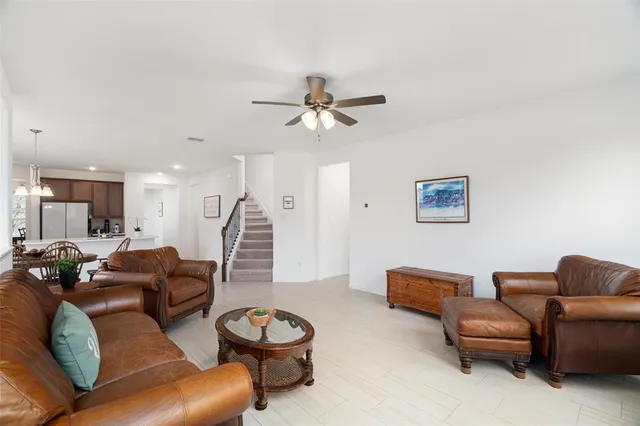 a living room with furniture a ceiling fan and a rug
