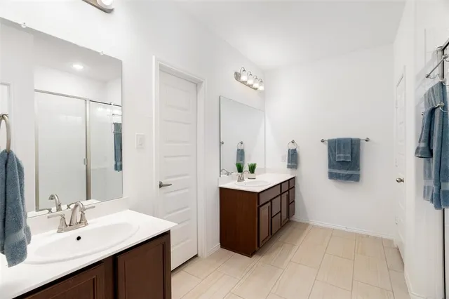 a spacious bathroom with a double vanity sink a mirror and a bathtub