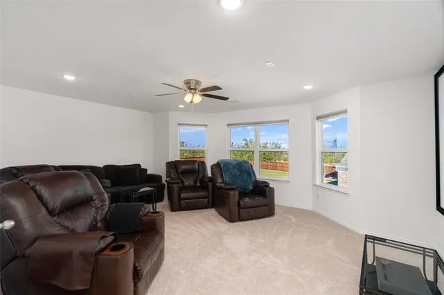 a living room with furniture ceiling fan and a window