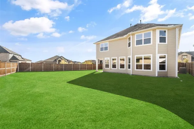 a view of house with a big yard and large trees