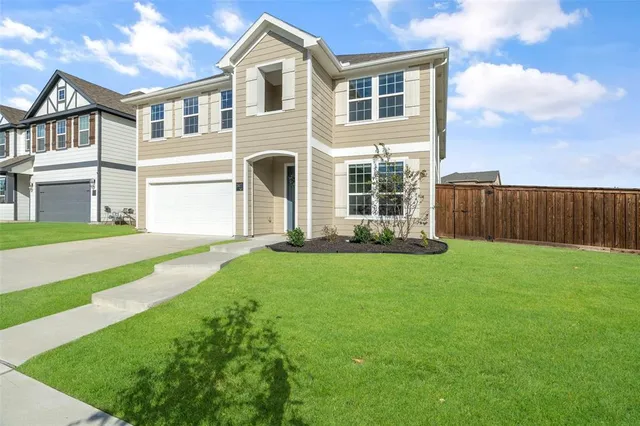 a front view of a house with a garden and yard